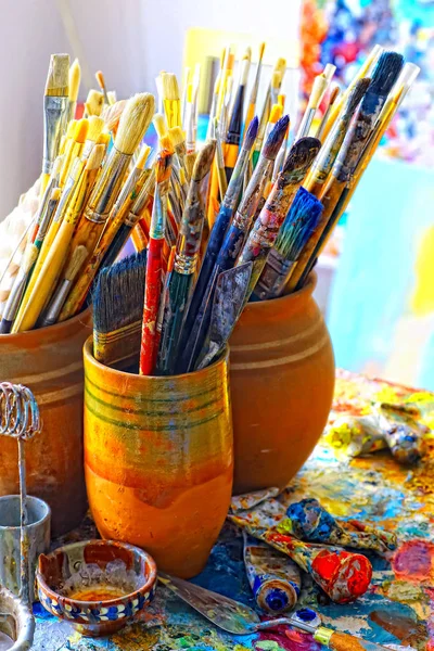 Paint brushes in the cup and palette paints - Stock Image - Everypixel